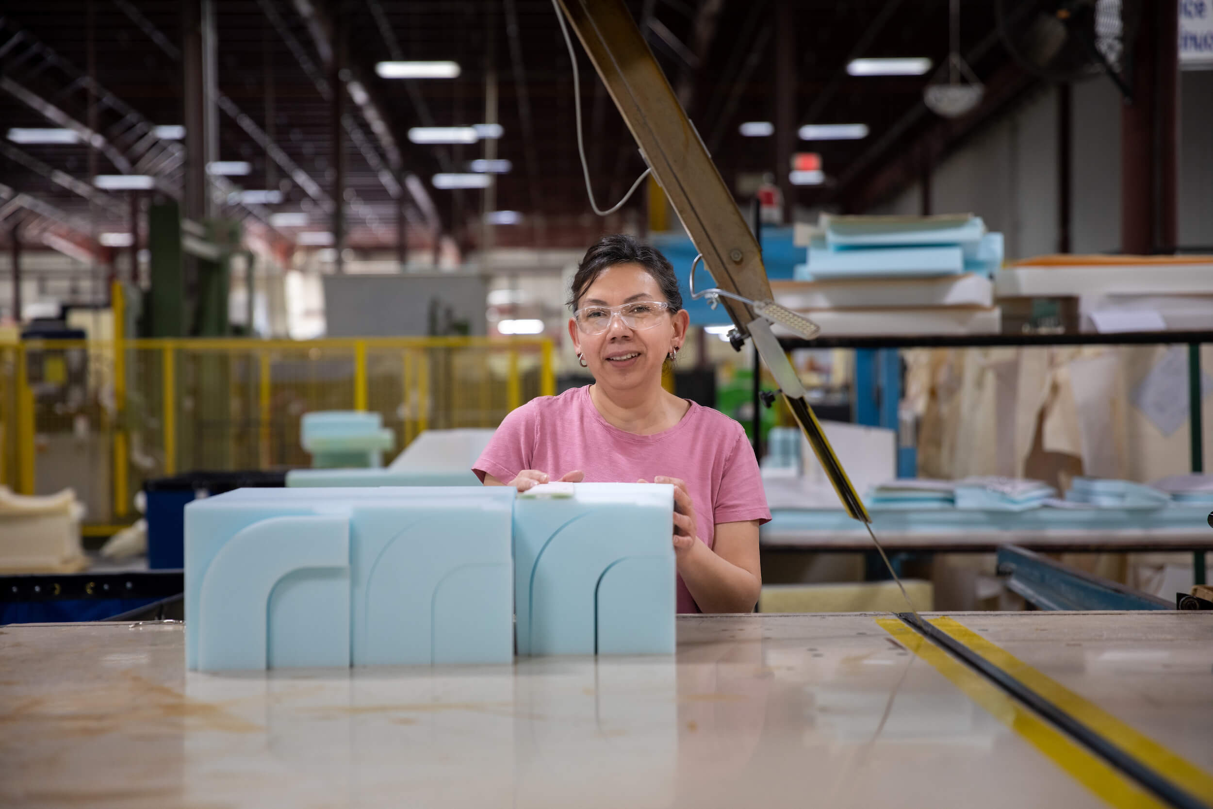 Experienced foam fabricator standing with newly cut foam at G&T Industries.